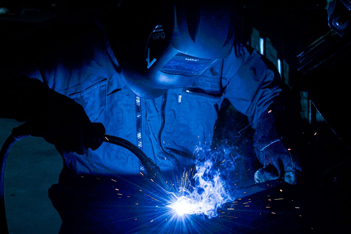 Débutant en train de souder à la torche, arc bleu et étincelles